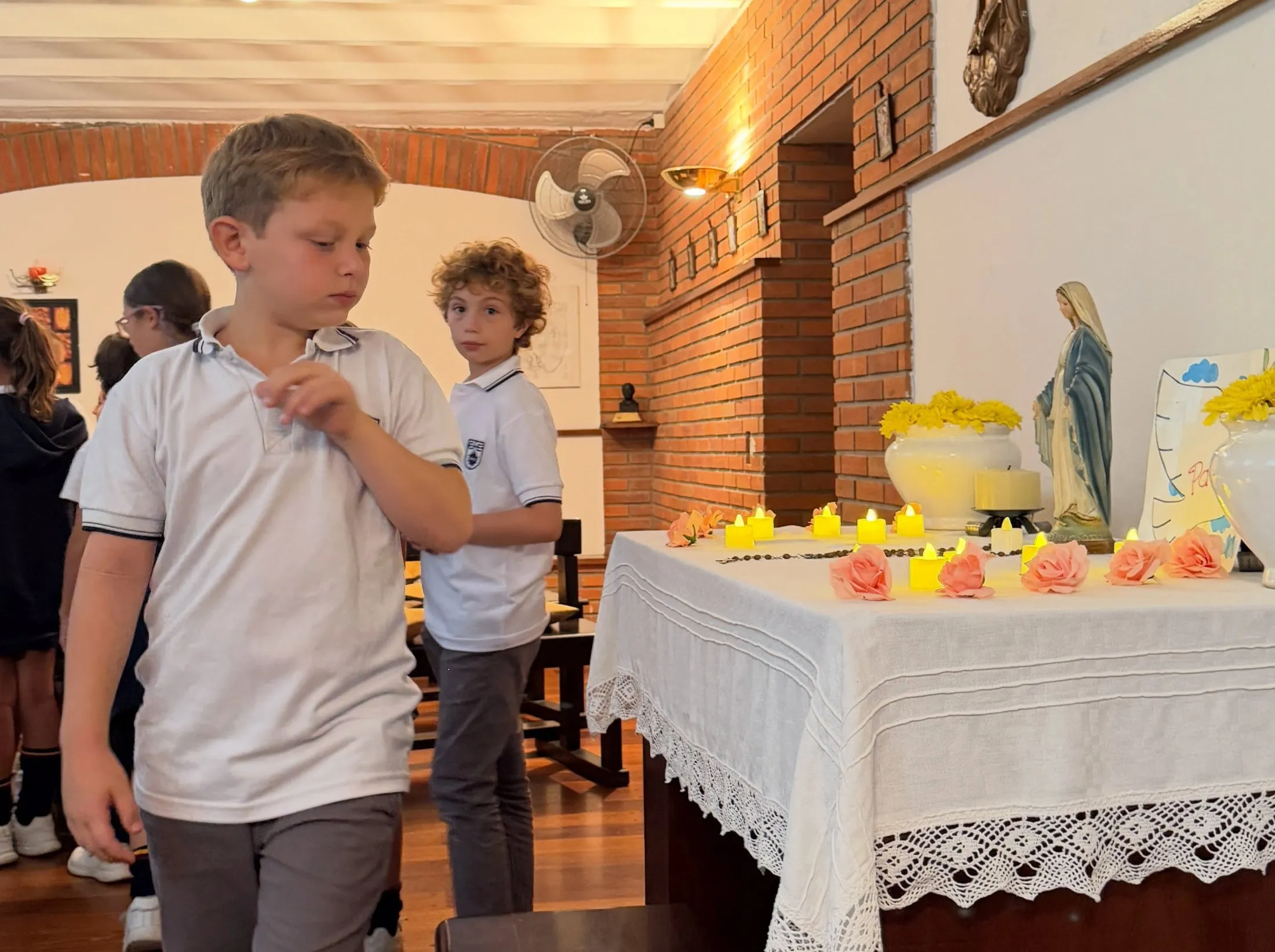 Alumnos de primaria frente al altar de la Virgen en la capilla del colegio