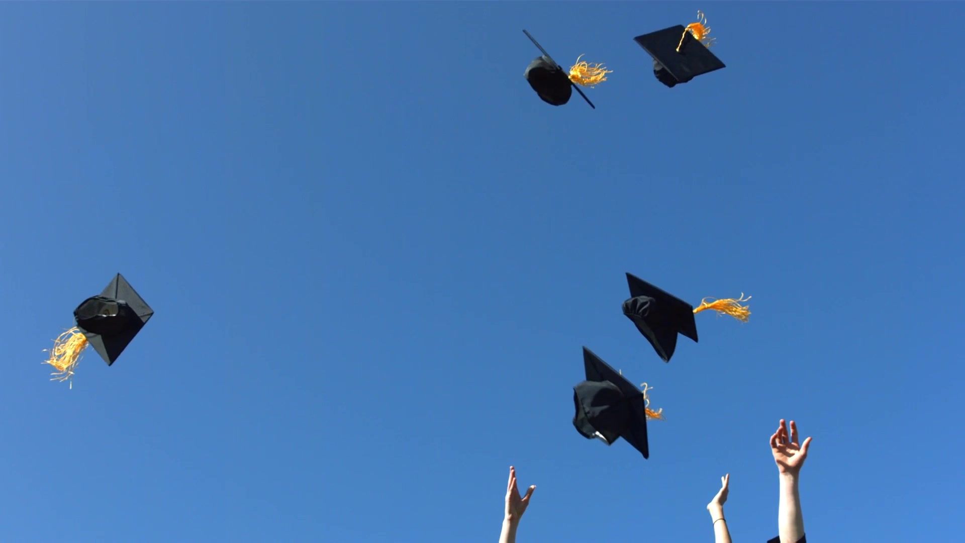 Birretes de egreso lanzados al cielo