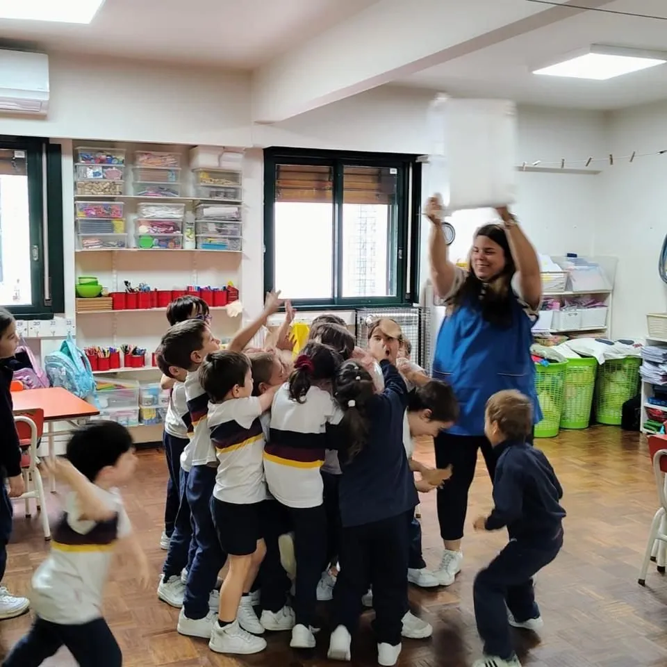 Una maestra jugando con los nenes de la sala en el jardín