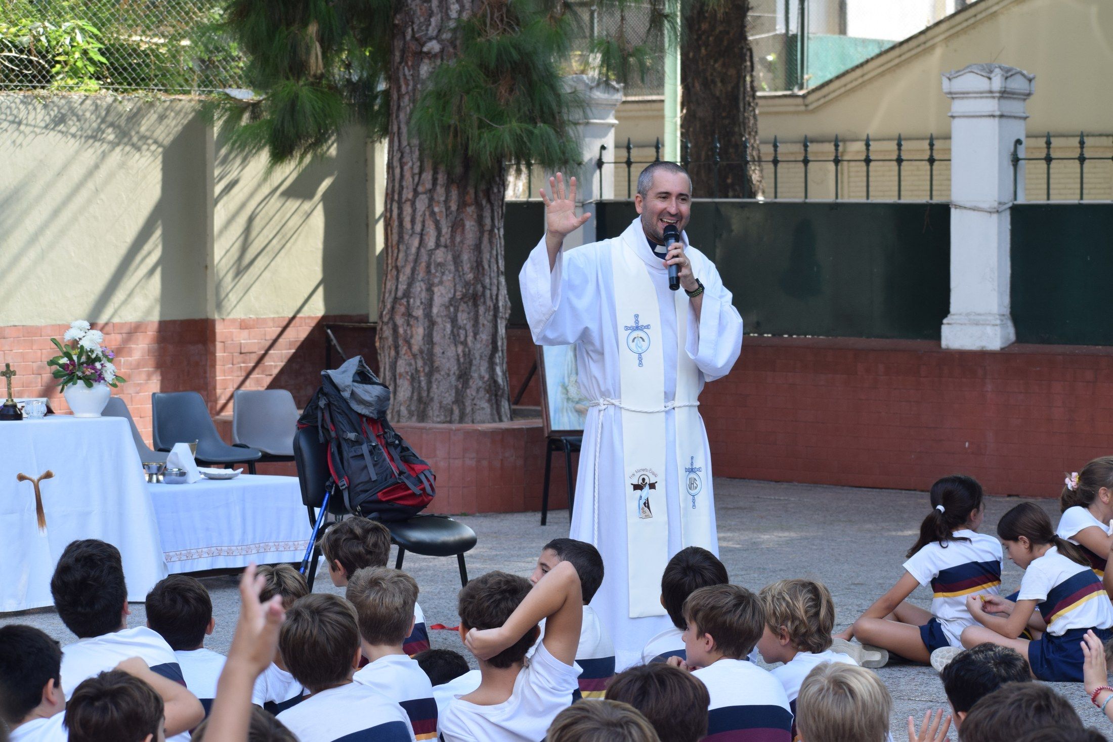 Misa de bendición de los misioneros en el patio del colegio, con la mochila de viaje junto al altar