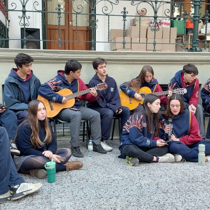Alumnos del secundario tocando guitarras y cajón peruano en el patio