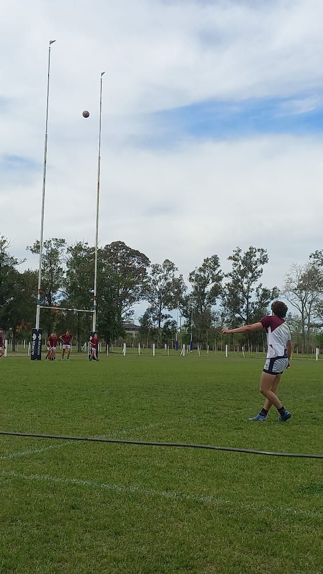 Alumno del secundario pateando a los palos durante un partido de rugby en el campo de deportes de Garín